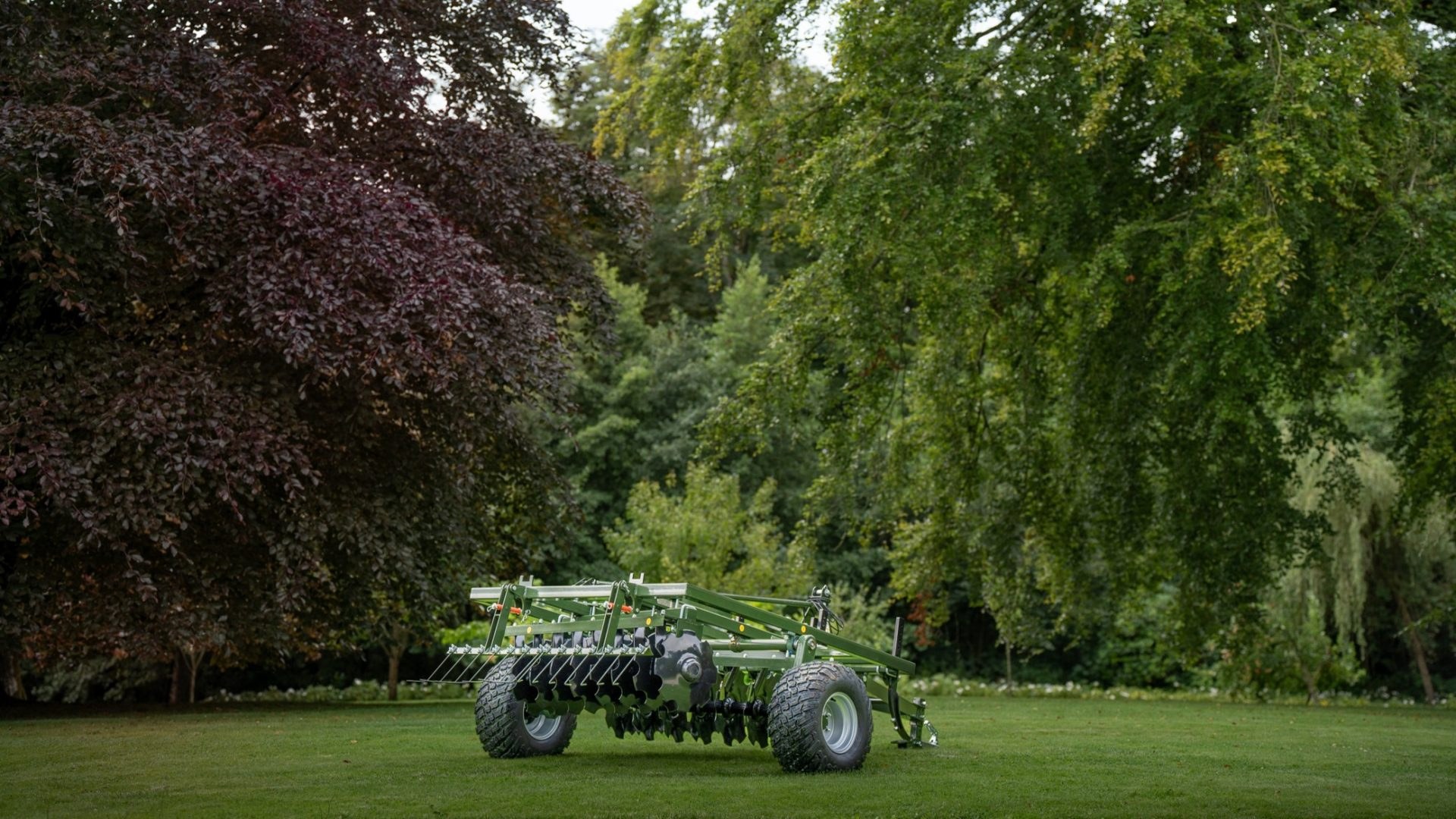 Faunamaster DH140 harrow on a mown lawn below large trees